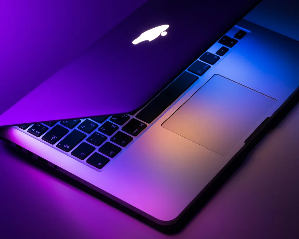 Pormenor de um computador portátil sob luz azul e violeta.
